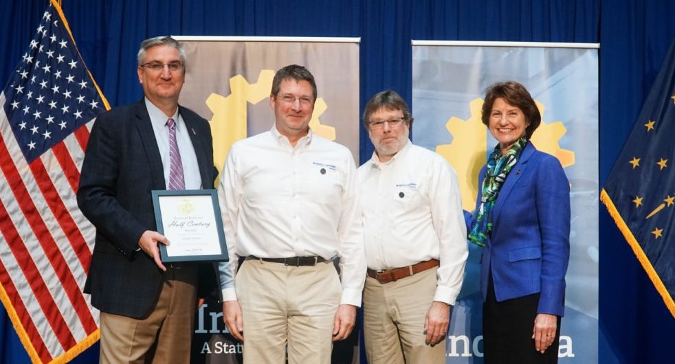 Four people pose for photo as Myers Spring Company with Governor's Half Century Award